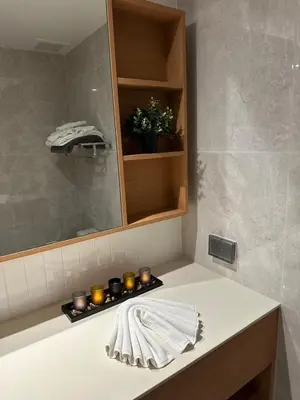 a bathroom with a sink with candles and a mirror at Laguna Beachside Residences 2bdr in Ban Thalat Choeng Thale