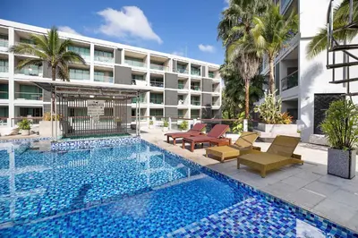 a swimming pool with chairs and a building at Stylish Stay, Quiet Vibe - Apartment RGN B411 in Bangtao in Bang Tao Beach