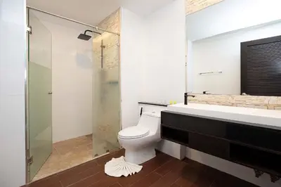 a bathroom with a toilet and a glass shower at Stylish Stay, Quiet Vibe - Apartment RGN B411 in Bangtao in Bang Tao Beach