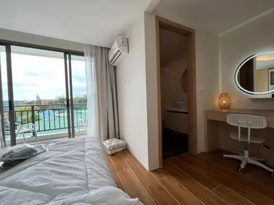a bedroom with a bed and a desk and a balcony at FANTASEA KAMALA NEW 1 BEDROOM & Living Room Balcony in Kamala Beach