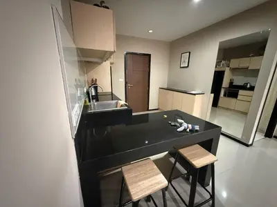 a kitchen with a black counter and two stools at апартаменты NBC Nai Harn in Rawai Beach