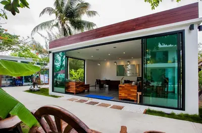 a glass house with a living room and dining room at Paradise Resort Phi Phi in Phi Phi Don
