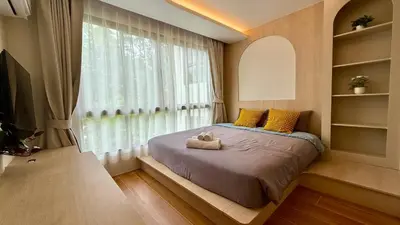 a bedroom with a bed with yellow pillows and a window at Apartment by the sea Kamala Beach A502 in Kamala Beach