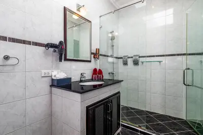 a bathroom with a sink and a glass shower at Luxurious & Quiet Pool Villa Orchid in Nai Yang Beach