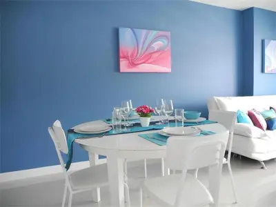 a dining room with a white table and chairs at 2 Bedrooms Beachfront Apartment in Patong in Patong Beach