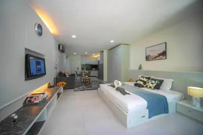 a bedroom with a large bed and a living room at Kamala Natural Modern ApartmentHigh Speed WiFiBig Living Room in Kamala Beach