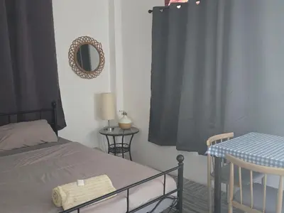 a bedroom with a bed and a mirror and a table at Kata Cozy Guest Room in Kata Beach