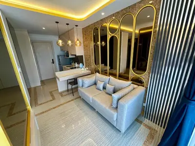 a living room with a blue couch and a bathroom at Bellevue lagoon 20 units in Laguna Phuket