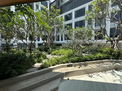 a bench in front of a building with trees at Bellevue lagoon 20 units in Laguna Phuket