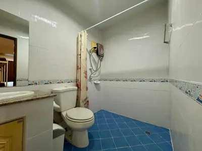 a white bathroom with a toilet and a shower at Ananas Central Phuket Hostel in Ban Ket Ho