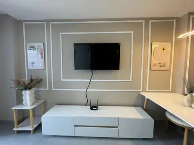 a living room with a tv on a wall at Condo for rent chalong rawai 305 in Ban Klang