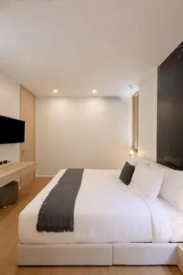 a bedroom with a white bed and a flat screen tv at Le Da Villas 5BR Private Pool Villa, Bangtao Beach Phuket in Laguna Phuket