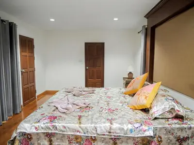 a bedroom with a large bed with a blanket on it at 3 Bedrooms - 2 floor with garden in Prime Location in Thalang