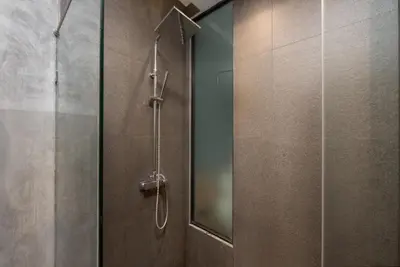a shower in a bathroom with a glass door at Relife Apartments by Tropiclook - Fast WiFi , Pool and Gym in Phuket Town