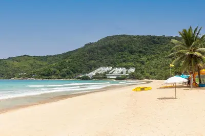 a beach with a yellow surfboard on the sand at Relife Apartments by Tropiclook - Fast WiFi , Pool and Gym in Phuket Town