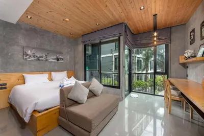 a bedroom with a bed and a couch and a desk at Relife Apartments by Tropiclook - Fast WiFi , Pool and Gym in Phuket Town