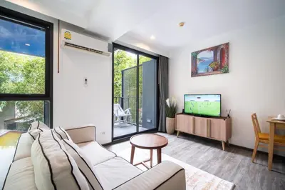 a living room with a couch and a tv at \u82ad\u4e1c\u6d77\u6ee9THEDECK166\u7cbe\u88c5\u516c\u5bd3\u9152\u5427\u8857Jungceylon10\u5206\u949f in Patong Beach