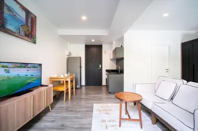 a living room with a white couch and a tv at \u82ad\u4e1c\u6d77\u6ee9THEDECK166\u7cbe\u88c5\u516c\u5bd3\u9152\u5427\u8857Jungceylon10\u5206\u949f in Patong Beach