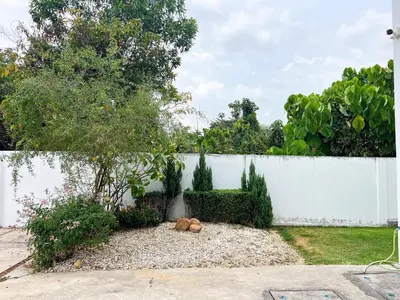 a garden with a fence and a dog laying on the ground at The Passion House in Ban Na Nai