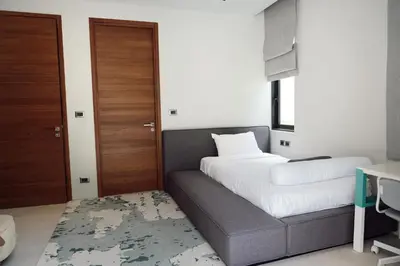 a bedroom with a bed and a couch with a desk at Villa Altessa 3BR Modern Loft II Botanica in Ban Pak Lak