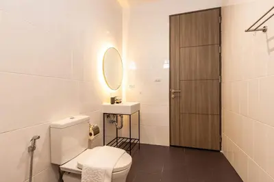 a bathroom with a toilet and a sink and a mirror at Bangtao Beach Walk Villa by Taan Residence in Bang Tao Beach
