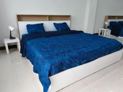a bedroom with a large bed with a blue comforter at Central House Phuket in Phuket Town