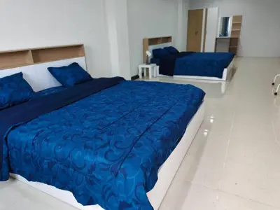 a bedroom with two beds with blue comforter at Central House Phuket in Phuket Town