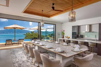 a dining room with a long table and chairs at Villa Narissa in Kamala Beach