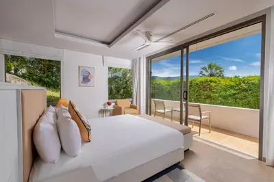 a bedroom with a bed and a large window at Villa Narissa in Kamala Beach