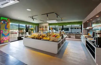 a restaurant with a counter with fruit on display at Utopia Phuket Naiharn Beach Grand Resort & Spa in Rawai Beach