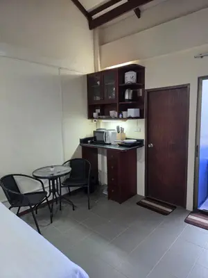 a room with a bed and a table and a kitchen at Monkey apartment 6 in Patong Beach