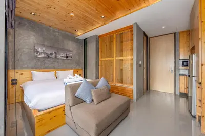 a bedroom with a bed and a chair in a room at Relife Zen 2 min to Nai Harn beach in Rawai Beach