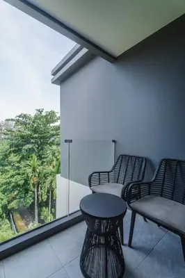 a balcony with two chairs and a table and a window at Stylish Beachfront Two-Bedroom Flat in Nai Thon Beach