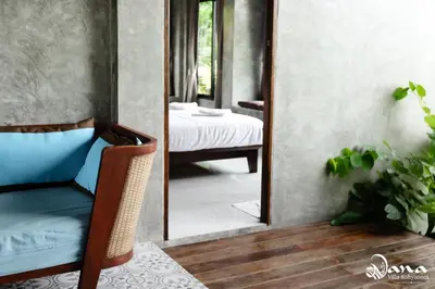 a mirror in a room with a chair and a bedroom at Nana Villa in Ko Yao Noi