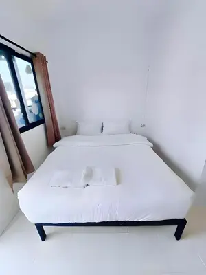 a white bed in a room with a window at xx BAO Patong Beach Phuket - เบา ป่าตองบีช in Patong Beach