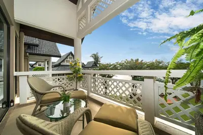 a balcony with chairs and a glass table at Stunning Lake View One Bedroom in Laguna Phuket