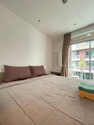 a large bed in a room with a large window at Sabai Stay in Patong Beach