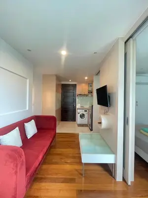 a living room with a red couch and a television at Sabai Stay in Patong Beach