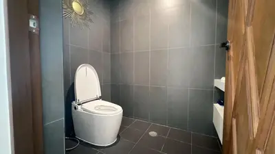 a bathroom with a white toilet in a room at Ocean home in Laguna Phuket