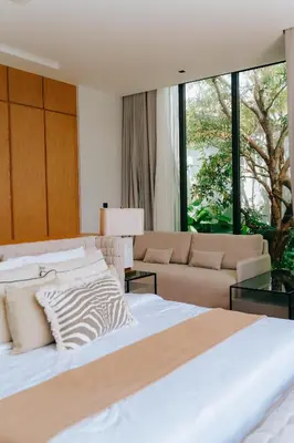 a bedroom with a large bed and a couch at Botanica Foresta Villa in Thalang