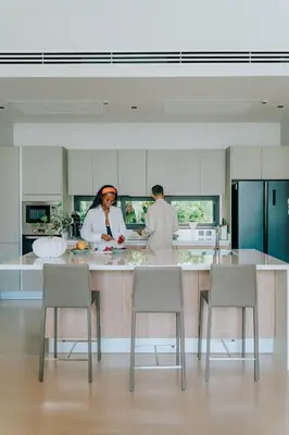 two people standing in a kitchen preparing food at Botanica Foresta Villa in Thalang