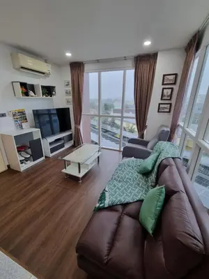 a living room with a couch and a television at Ozone Condotel Kata Beach by Pitjira in Phuket Town