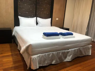 a bedroom with a large bed with two towels on it at Bel Air Panwa Big Apartment in south Phuket near Ao Yon Beach, 3rd floor in Ban Ao Makham