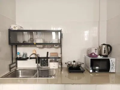 a kitchen with a sink and a microwave at Sila Apartment in Ban Thalat Choeng Thale
