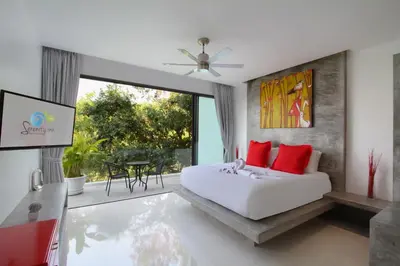 a bedroom with a white bed with red pillows at Serenity Villa in Bang Tao Beach