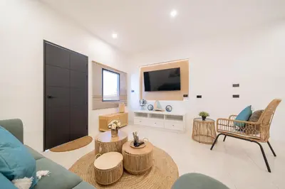 a living room with a couch and a tv at Wink Central 9 Patong Beach Phuket in Patong Beach