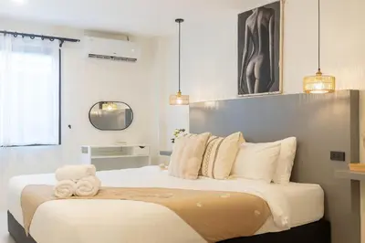 a bedroom with a large bed with two towels on it at Wink Central 9 Patong Beach Phuket in Patong Beach