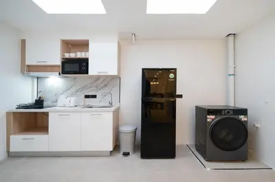 a kitchen with a washing machine and a microwave at Wink Central 9 Patong Beach Phuket in Patong Beach