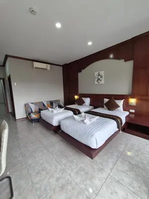 a hotel room with two beds and a couch at New Forest Patong Hotel, Patong Beach in Patong Beach