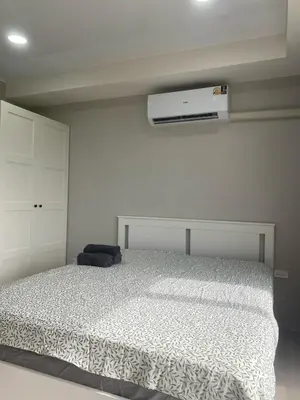a white bedroom with a bed and a heater at май кхао Студия в кондо 777 in Koh Lone